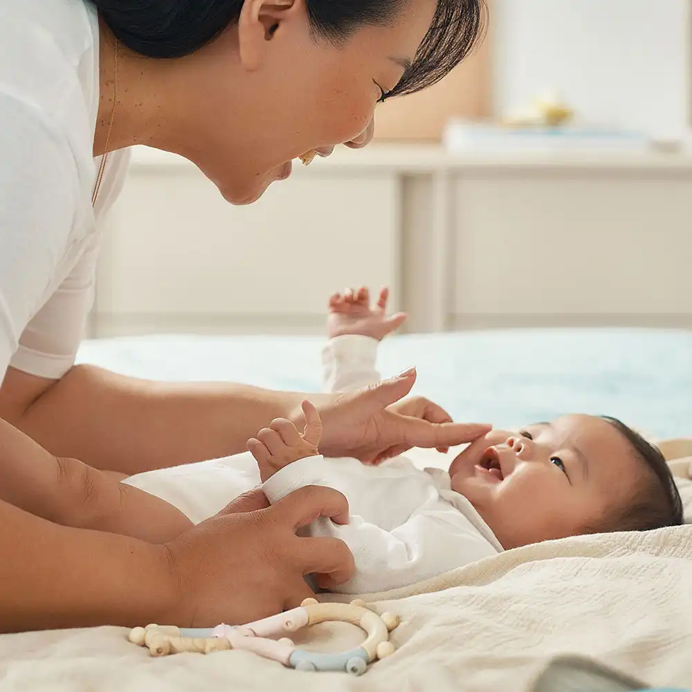 A mother applying Mustela massage oil, ready for baby massage masterclass at the baby expo in Brisbane